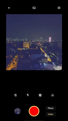 8mm vintage camera app showing nighttime city lights with red video button and camera controls in viewfinder