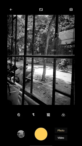 Black and white outdoor scene framed through window panes with vintage 8mm film camera effect